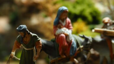 a nativity scene of two figurines on a donkey